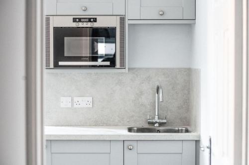 a kitchen with a sink and a microwave at The Kingswood Hotel in Sidmouth