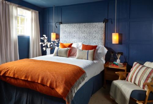 a blue bedroom with a large bed with an orange blanket at The Loft House - Beautiful House in Best Location in Bath