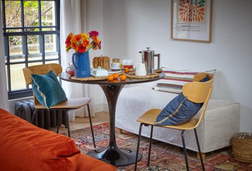a living room with a table with a vase of flowers at The Loft House - Beautiful House in Best Location in Bath