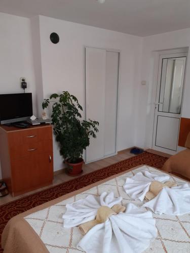 a bedroom with a large bed with towels on it at Guest House Stoletnika in Yagodina