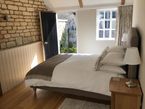 una camera con un grande letto e una finestra di Courtyard Cottage a Stroud
