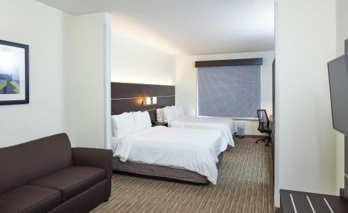 a hotel room with a bed and a couch at Holiday Inn Express Hotel & Suites- Gadsden by IHG in Gadsden