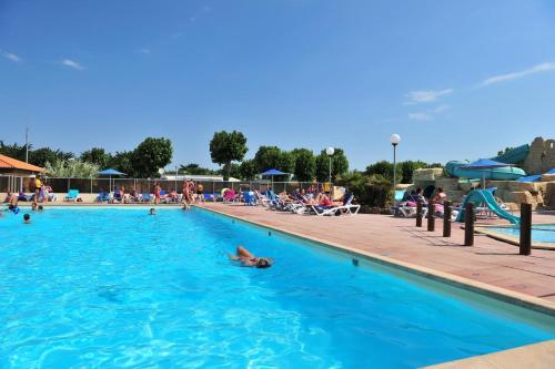 una persona nadando en una piscina en Mobil home BASSET au camping à St Hilaire de Riez 400m de la mer en Saint-Hilaire-de-Riez