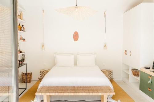 - une chambre blanche avec un lit dans l'établissement La Roussatino, à Saint-Étienne-du-Grès