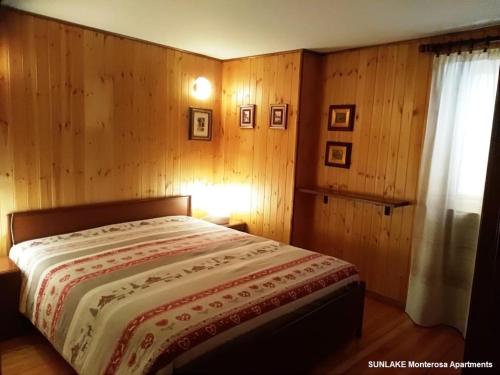 ブリュソンにあるSunlake - Estoulのベッドルーム1室(木製の壁と窓のあるベッド1台付)