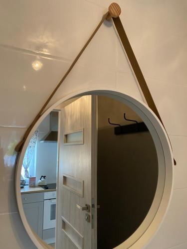 a round mirror in a room with a door at Stara Studnia in Brzeźnica Stara