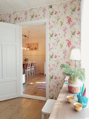 Zimmer mit einem Spiegel und einem Esszimmer mit Blumentapeten in der Unterkunft Palade Retrovisiit Meida in Palade