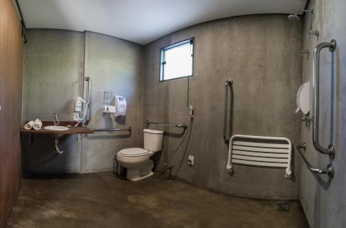 a bathroom with a toilet and a sink at Hotel Fazenda Terra dos Sonhos in Bueno Brandão