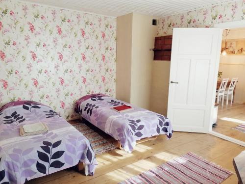 two beds in a room with floral wallpaper at Palade Retrovisiit Meida in Palade