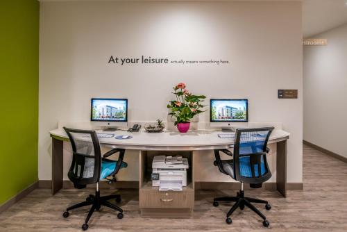 an office with a desk with two monitors and two chairs at EVEN Hotel Eugene by IHG in Eugene