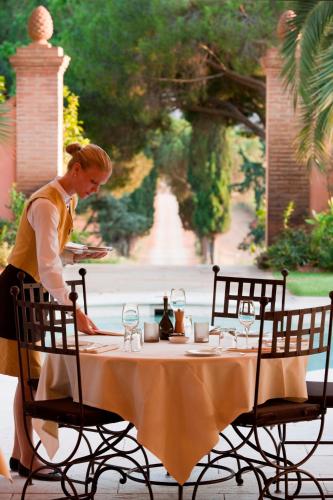 a woman standing in front of a table with a plate of food at L'Andana Tenuta La Badiola in Castiglione della Pescaia