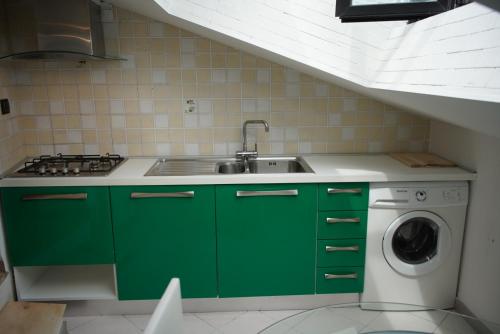 een groene keuken met een wastafel en een wasmachine bij LA GHIBELLINA. confortevole,posizione privilegiata in Siena