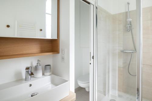 a white bathroom with a shower and a toilet at La Perle Marine in Dinard