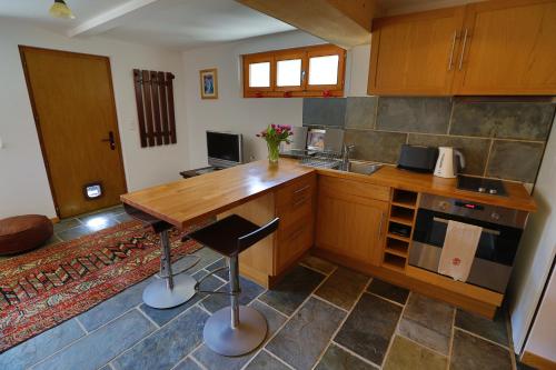 a kitchen with a wooden counter top and a table at Matapouri in Le Châble