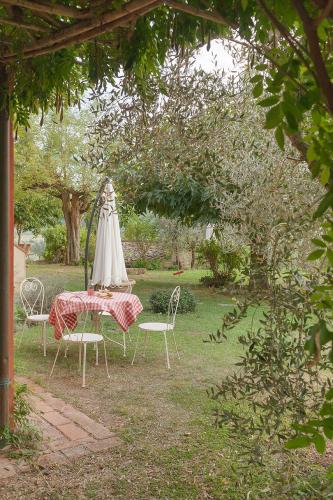 a table and chairs with an umbrella in a garden at Agriturismo La Ca'Solare in Palaia