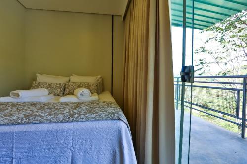 a bedroom with a bed next to a balcony at Hotel Fazenda Terra dos Sonhos in Bueno Brandão