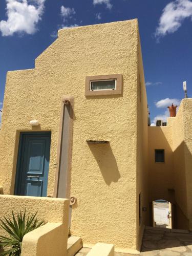 a building with a blue door on the side of it at Porto Sisi Hotel Apartments in Sissi