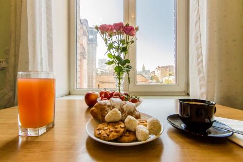 a plate of food on a table with a glass of orange juice at Однокімнатні апартаменти на Майдані, дистанційне заселення 24х7 in Kyiv