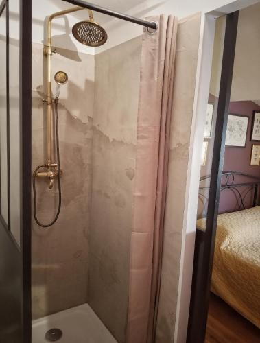 une douche avec une porte vitrée dans une salle de bain dans l'établissement La Dolce Vita - Chambre Amerigo Vespucci, à Montpeyroux