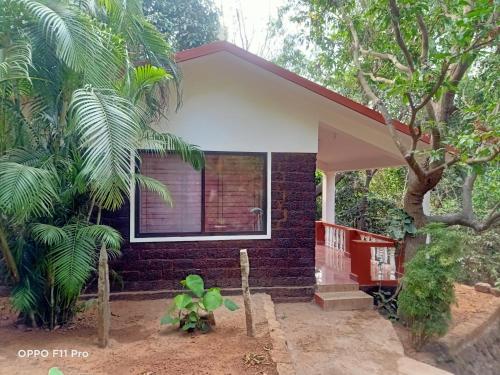 a house that has a tree in the front of it at Namaste Yoga Farm in Gokarna