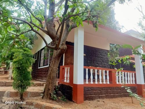 a house with a tree in front of it at Namaste Yoga Farm in Gokarna