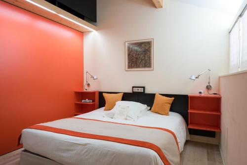 a bedroom with a large bed with orange walls at Hôtel-Restaurant le Château de Besseuil, Mâcon Nord - Teritoria in Clessé