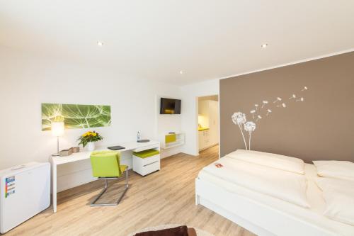 a bedroom with a white bed and a desk at acora Fürth Living the City- Apartments in Fürth