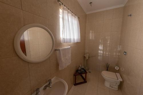 a bathroom with a sink and a toilet and a mirror at Casa com WiFi e lazer em Campina Grande do Sul in Campina Grande do Sul