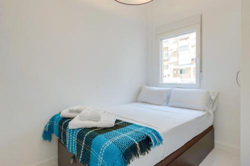 マドリードにあるNice and Cozy Apartment in Deliciasの白いベッドルーム(窓付きのベッド付)