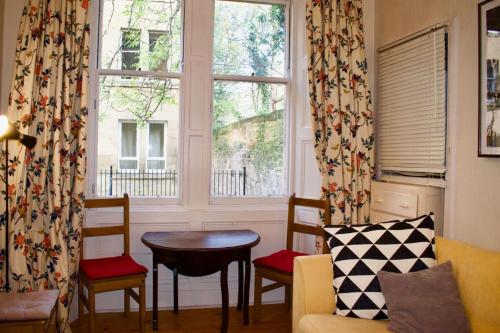 sala de estar con mesa, sillas y ventana en Central 3 Bedroom next to Leafy Meadows en Edimburgo