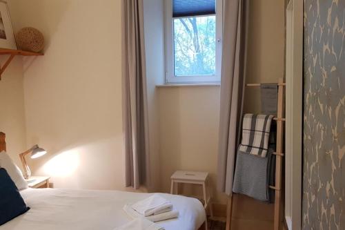 Habitación pequeña con cama y ventana en Central 3 Bedroom next to Leafy Meadows en Edimburgo