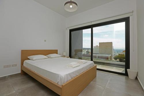 une chambre avec un lit et une grande fenêtre dans l'établissement Villa Oniron, à Coral Bay