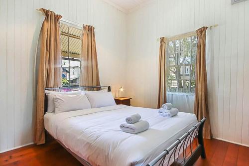 a bedroom with a large bed with towels on it at Walk to the Charming Character Home in Brisbane