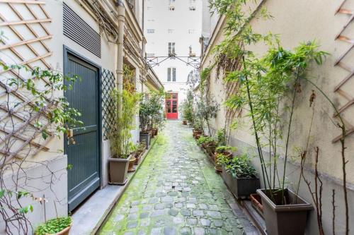 an alley with potted plants on the side of a building at Amazing 2 Bedroom Parisian flat in Paris