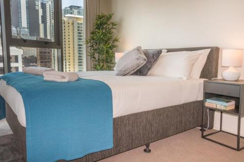 a bedroom with a bed with a blue blanket on it at 1 Bed Studio Apartment Near Eagle Street in Brisbane