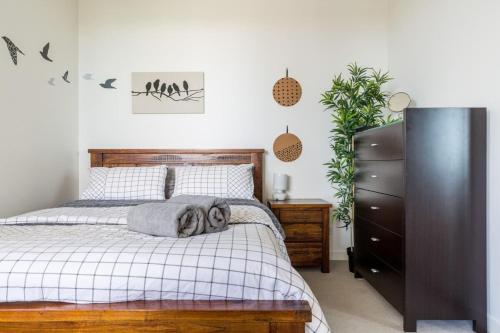a bedroom with a bed and a dresser at Modern 1 Bedroom in Tranquil Parklands in Melbourne
