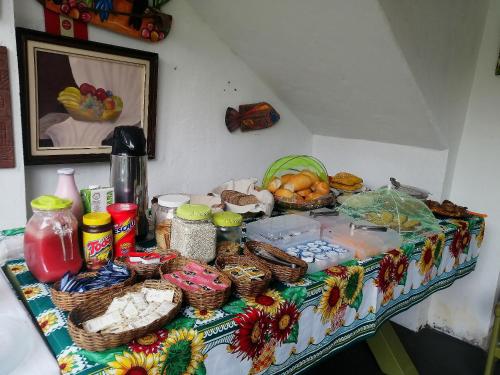 einen Tisch mit Lebensmitteln und Körben mit Lebensmitteln darauf in der Unterkunft Pousada Recanto dos Pássaros in Trindade