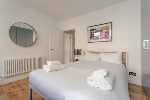 ロンドンにあるModern 1 Bed Flat in Central Londonのベッドルーム1室(白いベッド1台、タオル付)