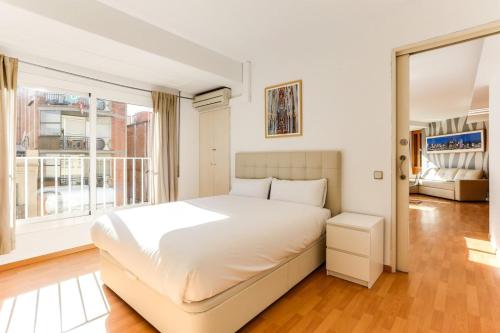 1 dormitorio con cama blanca y ventana grande en Luminous 2 Bedroom next to Sagrada Familia, en Barcelona