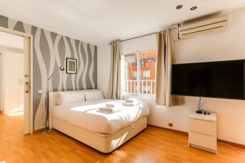 1 dormitorio con 1 cama y TV de pantalla plana en Luminous 2 Bedroom next to Sagrada Familia, en Barcelona