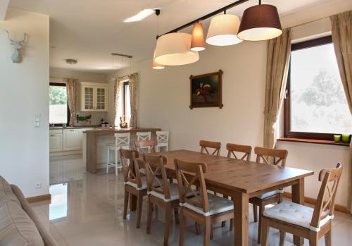 a kitchen and dining room with a wooden table and chairs at Hotel SPA Dr Irena Eris Wzgórza Dylewskie - Siedliska in Wysoka Wieś