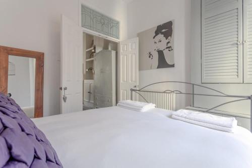 ロンドンにあるStylish 1 Bed Apartment Near Battersea Parkのベッドルーム1室(大きな白いベッド1台、タオル付)