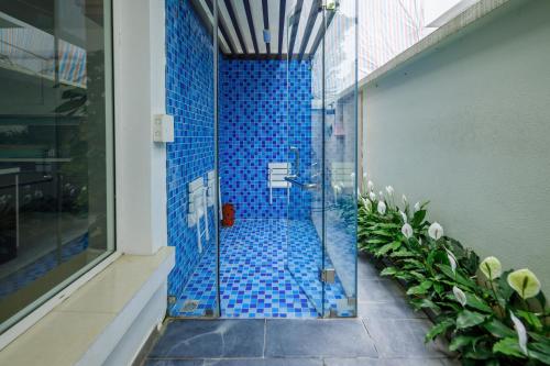 a bathroom with a shower with blue tiles at An Phú Villa and Golf FLC Sầm Sơn in Sầm Sơn