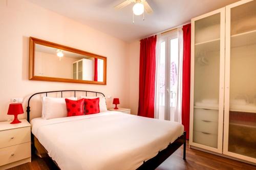 バルセロナにあるModern 2 Bedroom Flat in Trendy Poble Secのベッドルーム1室(赤い枕と鏡付きのベッド1台付)