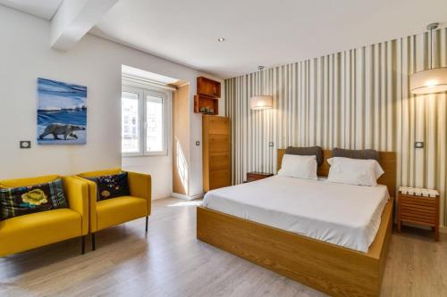 リスボンにあるCharming 2 bedroom apartment at Resteloのベッドルーム1室(ベッド1台、黄色い椅子2脚付)