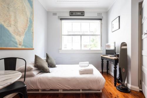 a bedroom with a bed and a desk and a window at Boutique Studio Apartment at Potts Point in Sydney