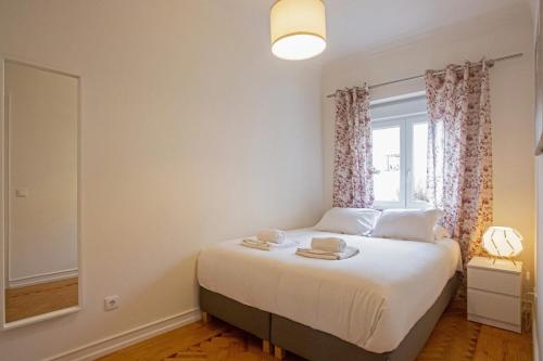 a small bedroom with a bed with a window at Cosy 1 Bedroom Apartment in Belém in Lisbon
