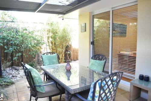 a dining table and chairs on a patio at Bright 2 Bedroom Apartment In A Great Location in Perth