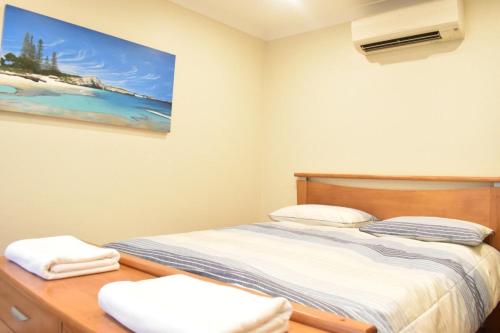 um quarto com uma cama e um quadro na parede em Bright 2 Bedroom Apartment In A Great Location em Perth