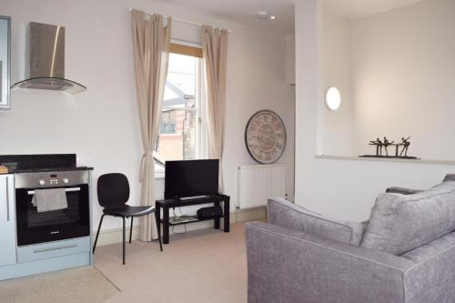 a living room with a couch and a tv at Stylish light-filled 1 Bedroom Flat In Hammersmith in London